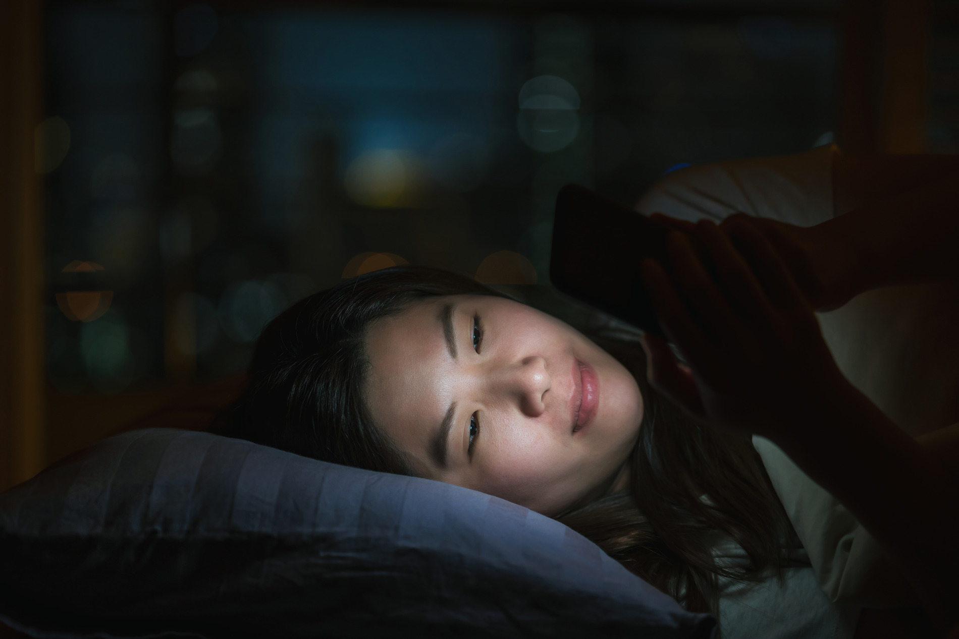 a woman using phone in bed