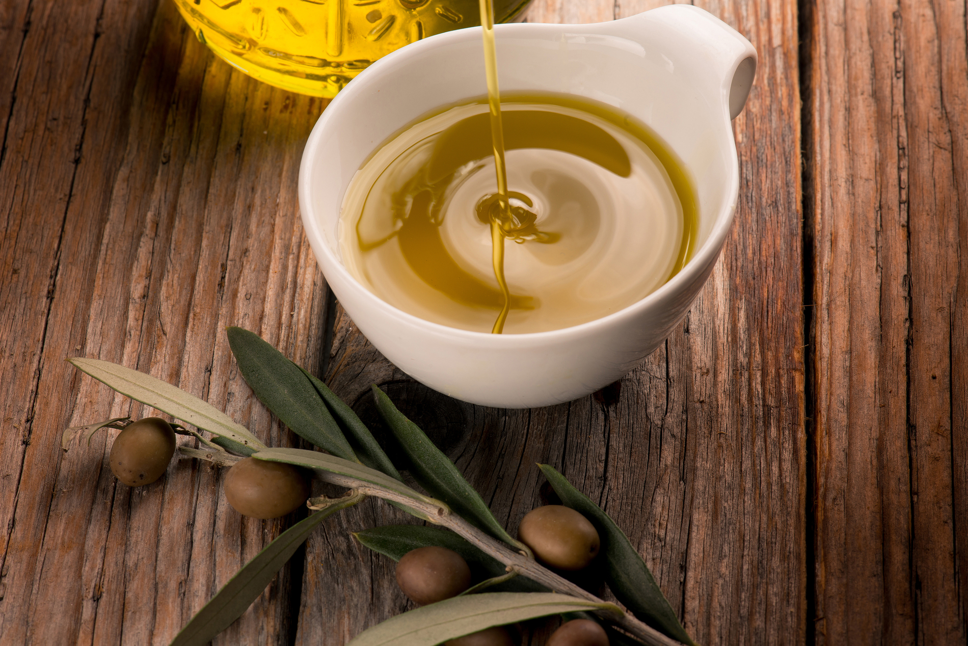Olive oil pouring into a bowl