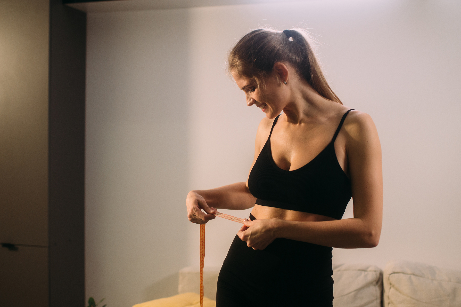 woman measuring her waist
