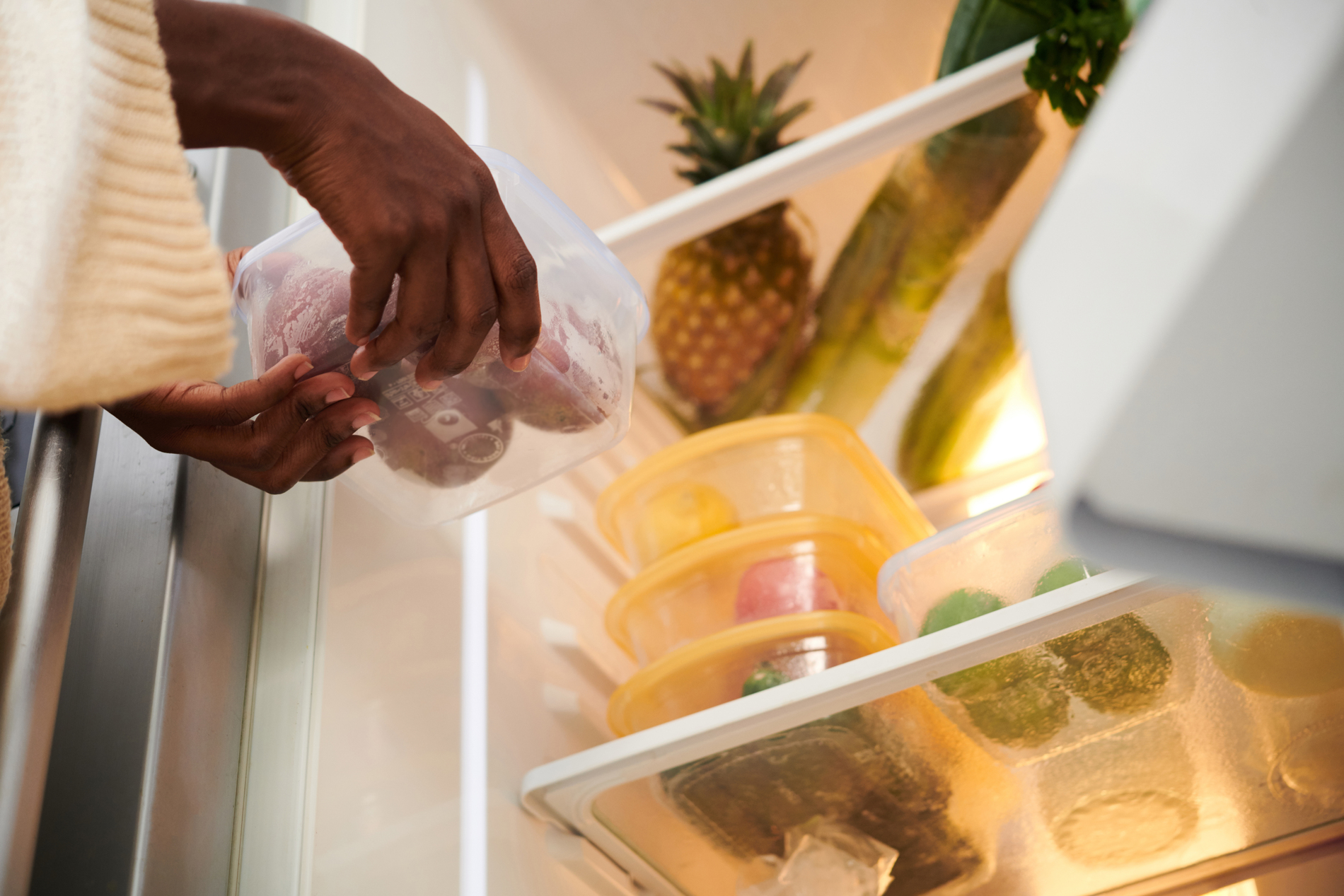 Woman putting food in refrigerator